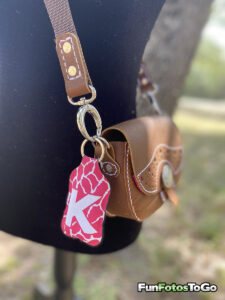 customized hand sanitizer holder hanging from handmade leather bag from Tiny Anvil Leather